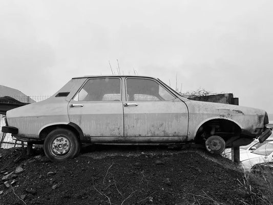 Old abandoned car on a dirt mound